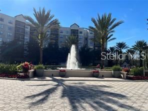 A multi-story apartment building stands behind a central fountain and palm trees — 14501 GROVE RESORT AVENUE UNIT 3535, WINTER GARDEN, FL