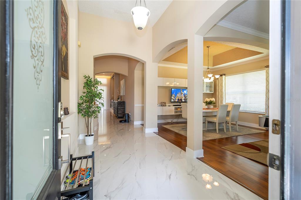 A view from an entryway into a home with marble floors and a dining area — 10301 OAKVIEW POINTE TERRACE, GOTHA, FL