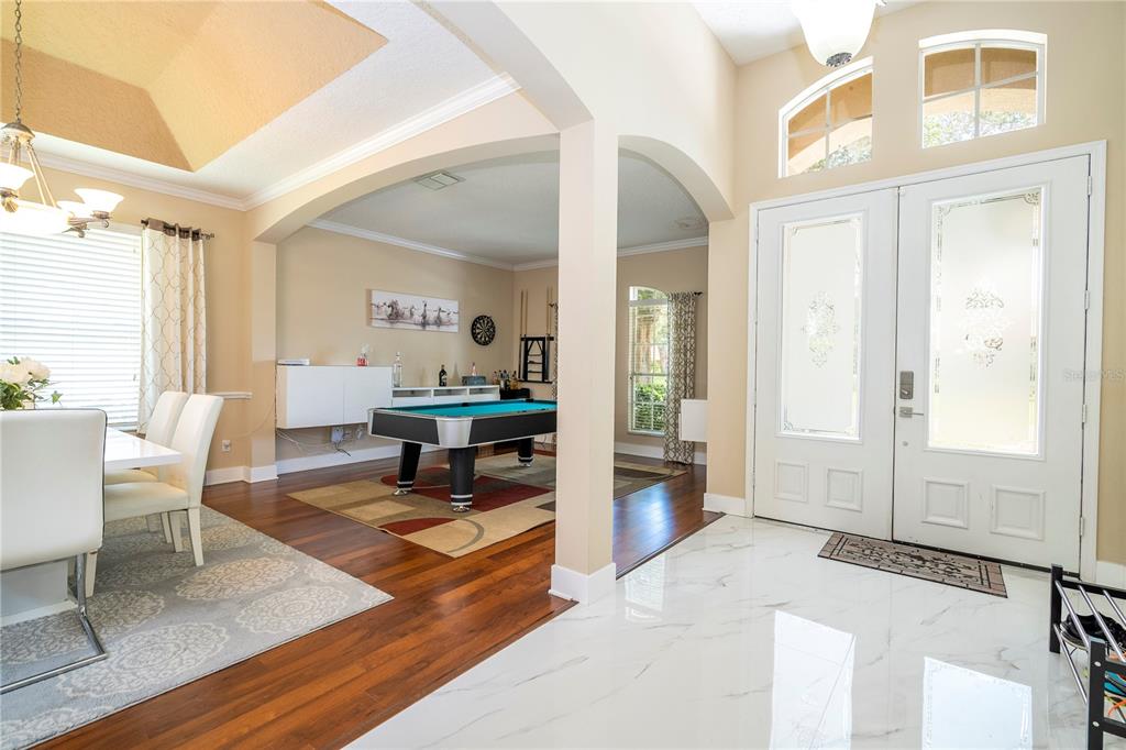 An entryway with marble floors leads to a dining area and a room with a pool table — 10301 OAKVIEW POINTE TERRACE, GOTHA, FL