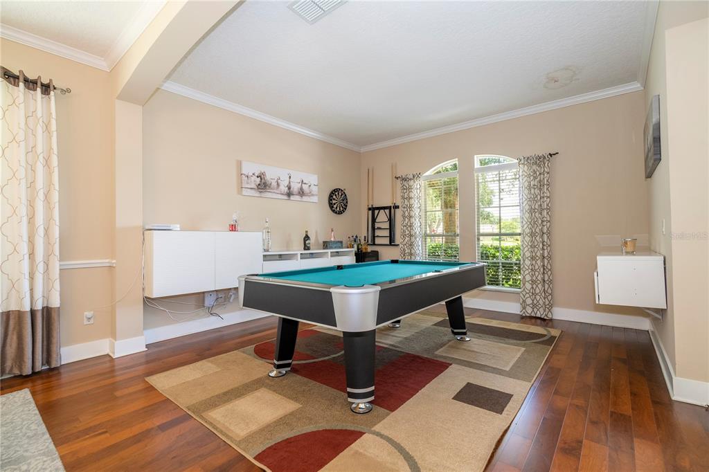A game room features a pool table, a patterned area rug, and hardwood flooring — 10301 OAKVIEW POINTE TERRACE, GOTHA, FL