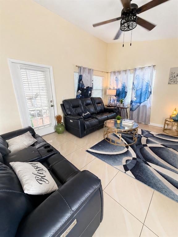A living room features black leather sofas, a glass coffee table, and blue patterned curtains — 3843 WEETAMOO CIRCLE, ORLANDO, FL