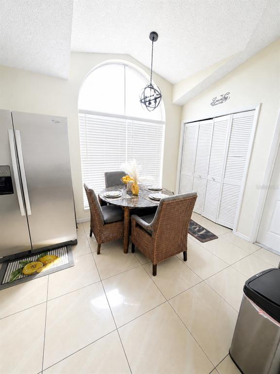 A kitchen dining area features a round table, wicker chairs, tile flooring, and a large window — 3843 WEETAMOO CIRCLE, ORLANDO, FL