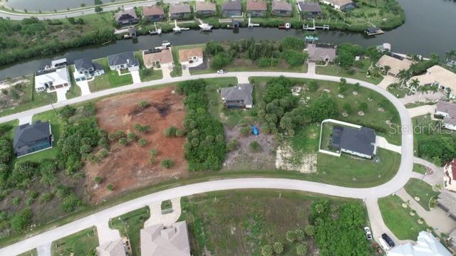 An aerial view shows a vacant residential lot situated between two houses in a neighborhood — 15157 LEIPZIG CIRCLE, PORT CHARLOTTE, FL
