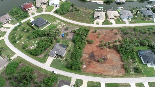 An aerial view shows a vacant residential lot surrounded by houses and a curved road — 15157 LEIPZIG CIRCLE, PORT CHARLOTTE, FL