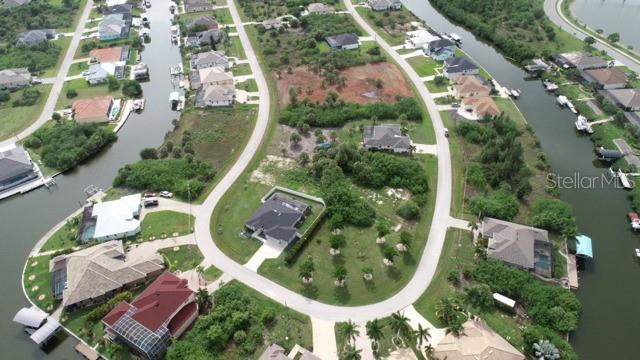 An aerial view shows waterfront homes along a canal in a residential neighborhood — 15157 LEIPZIG CIRCLE, PORT CHARLOTTE, FL