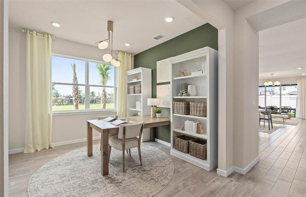 A home office features a wooden desk, white bookshelves, and a green accent wall — 2617 HAMMOCK HARBOR AVENUE, ST CLOUD, FL