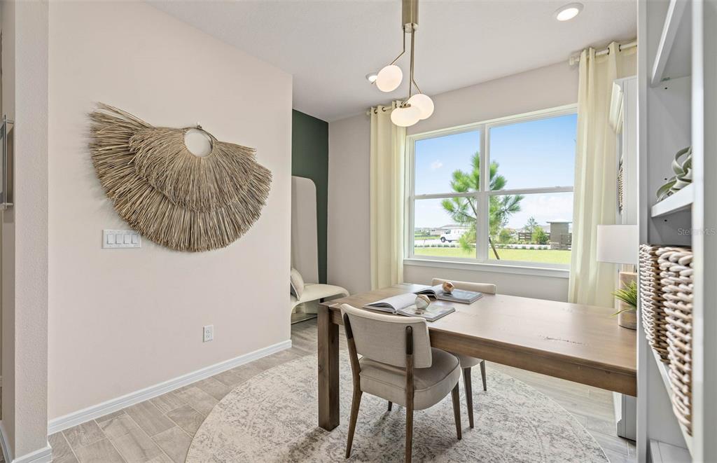 A home office features a wooden desk, a round area rug, and a wall-mounted decoration — 2617 HAMMOCK HARBOR AVENUE, ST CLOUD, FL