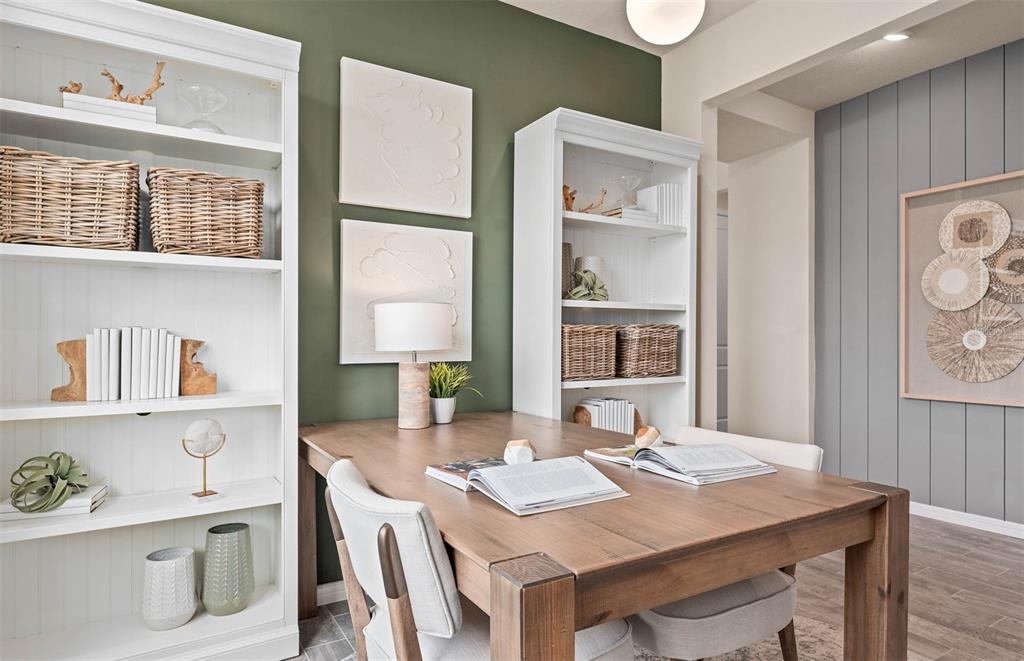 A home office features a wooden desk, two white bookshelves, and a green accent wall — 2617 HAMMOCK HARBOR AVENUE, ST CLOUD, FL