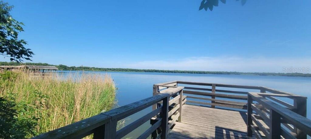 A wooden observation deck overlooks a calm lake surrounded by tall grass and trees — 268 TAVESTOCK LOOP, WINTER SPRINGS, FL