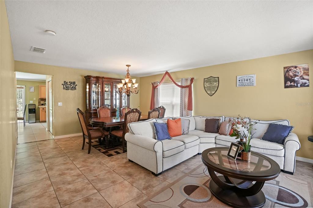 A living room and dining area with tile floors, a sectional sofa, and a hutch — 268 TAVESTOCK LOOP, WINTER SPRINGS, FL