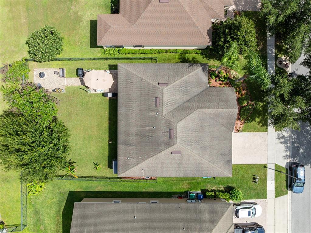 An aerial view shows a residential house with a shingled roof, backyard patio, and driveway — 8126 CRUSHED PEPPER AVENUE, ORLANDO, FL