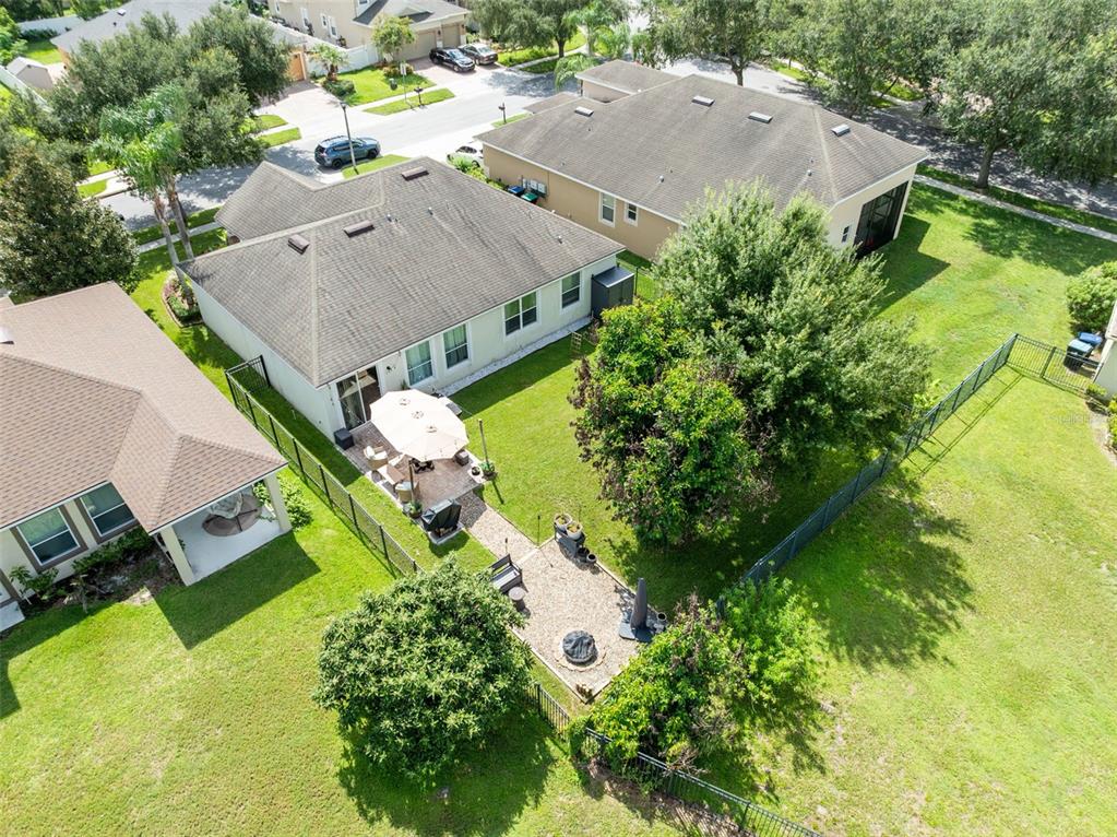 An aerial view shows a suburban house with a fenced backyard, patio, and large trees — 8126 CRUSHED PEPPER AVENUE, ORLANDO, FL