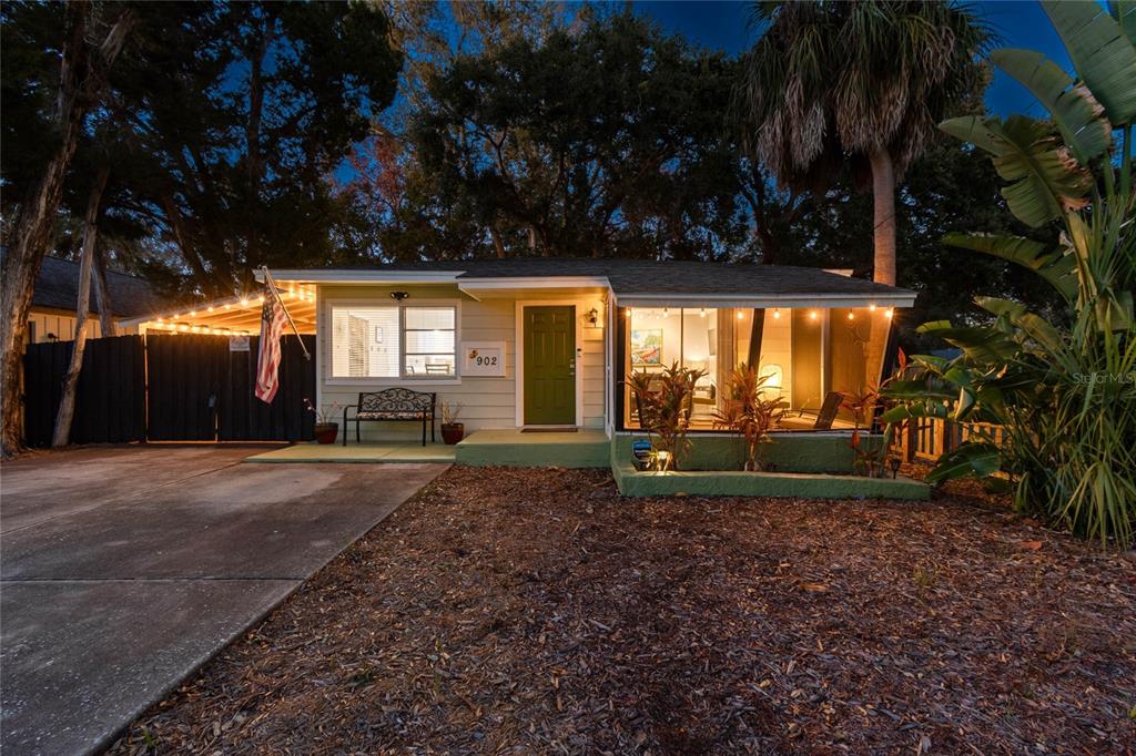 An aerial view shows a single-story house with a red arrow pointing to its roof — 902 BELTREES STREET, DUNEDIN, FL