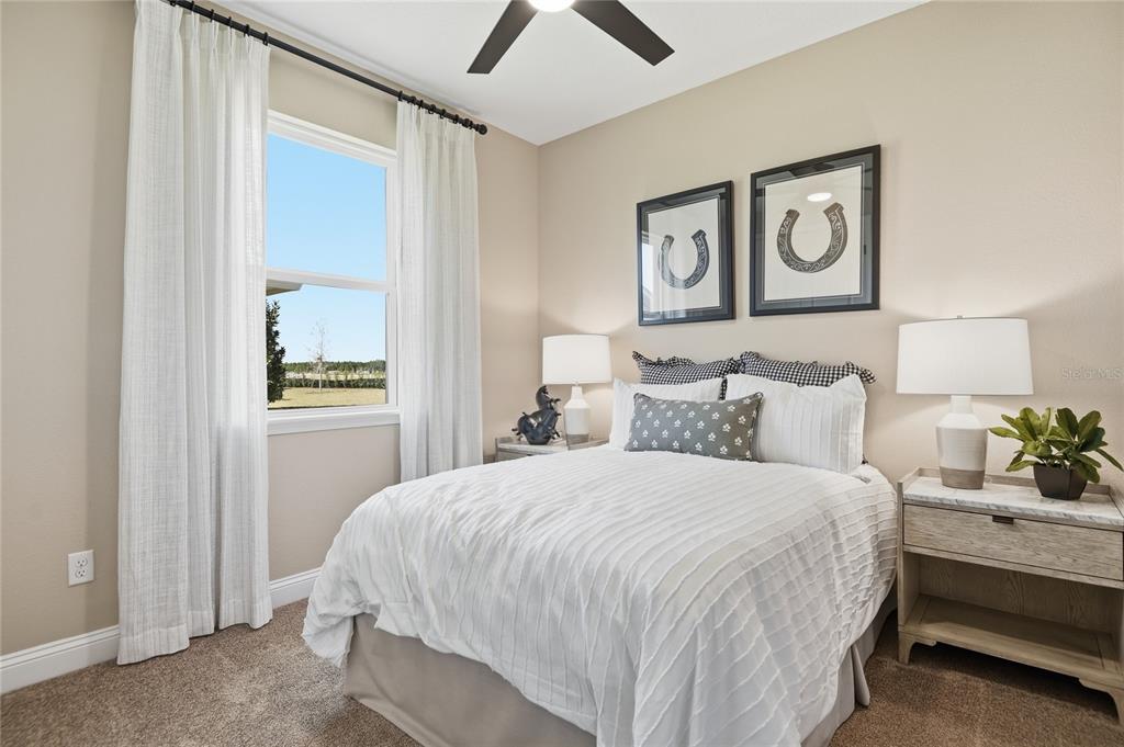 A bedroom features a bed with white bedding, two nightstands with lamps, and framed artwork — 218 THORNBERRY WAY, PALM COAST, FL