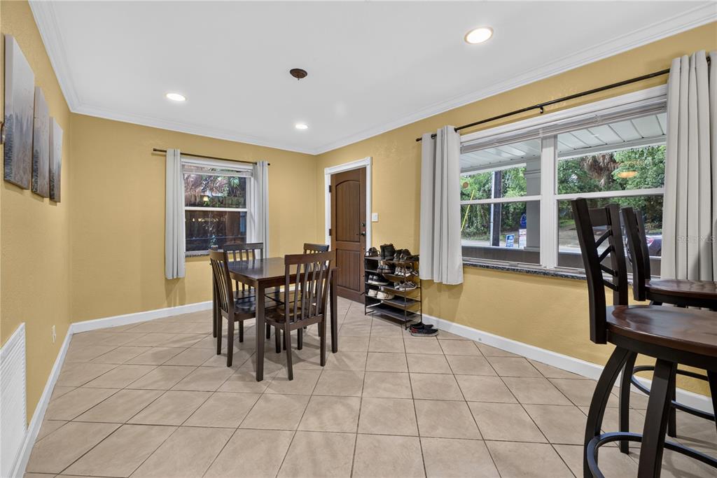 A dining room with yellow walls, tile flooring, a wooden table, and a shoe rack — 2511 KILGORE STREET, ORLANDO, FL