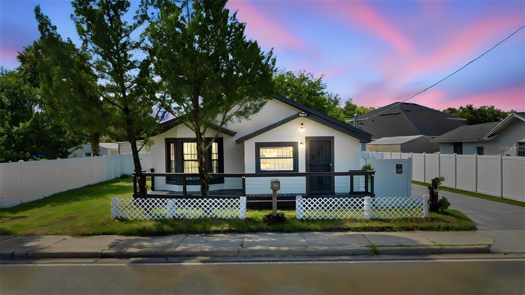 A single-story house with a white exterior, a front deck, and a lattice fence — 1416 SOUTHWEST ROAD, SANFORD, FL