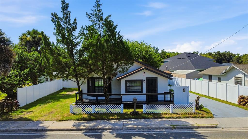 A white single-story house with a dark wooden deck and a white lattice fence — 1416 SOUTHWEST ROAD, SANFORD, FL