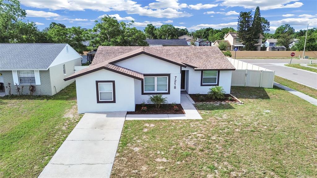 A single-story white house with a brown roof and a concrete driveway — 7218 LUNITA COURT, TAMPA, FL