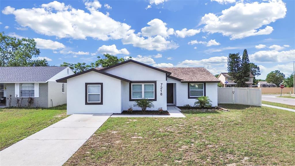 A single-story white house with a brown roof and a concrete driveway — 7218 LUNITA COURT, TAMPA, FL