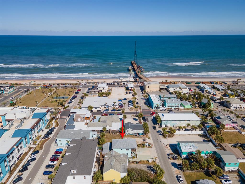 An aerial view shows a light blue house with a red arrow pointing to it — 208 S 3RD STREET, FLAGLER BEACH, FL