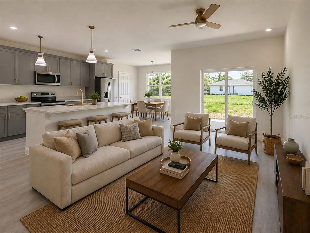 An open-concept living room and kitchen featuring gray cabinetry, a large island, and neutral furniture — 324 CONDOR AVENUE, SEBRING, FL