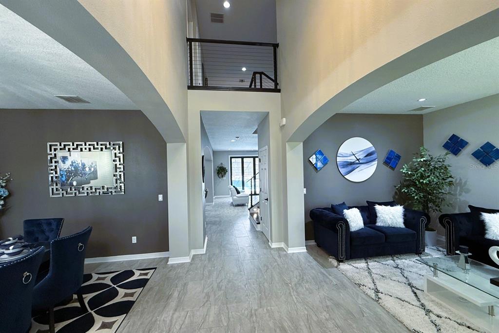A view from a tiled entryway looking toward a living area and a lofted balcony — 19313 PUMMELO DRIVE, ORLANDO, FL