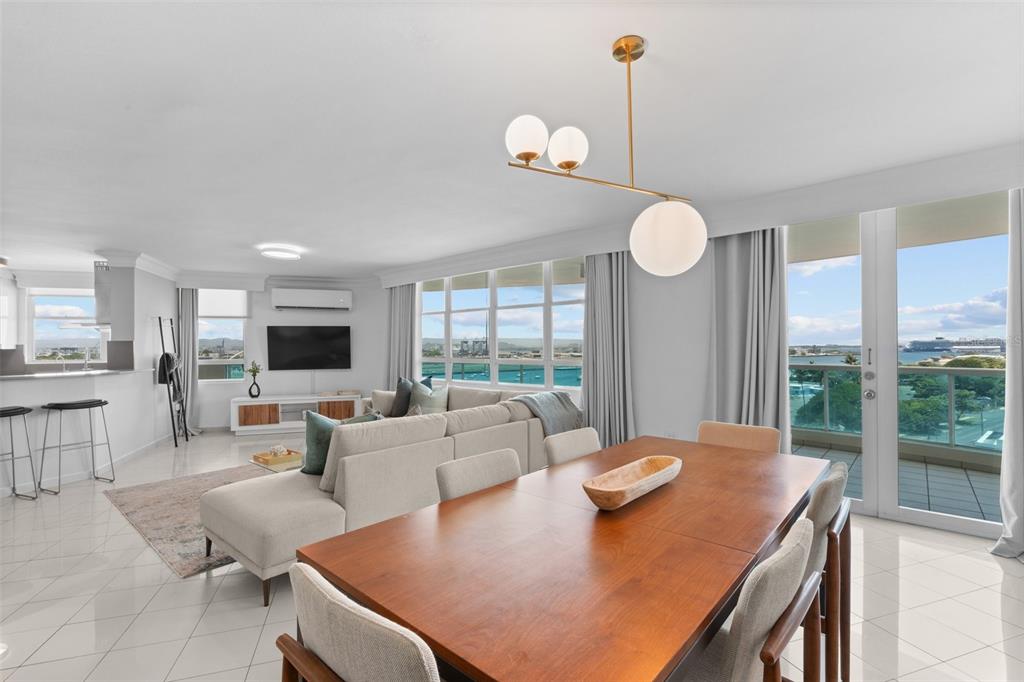 An open-concept living and dining area features tile floors, a modern chandelier, and balcony views — 550 AVE DE LA CONSTITUCION UNIT 1010, SAN JUAN, PR