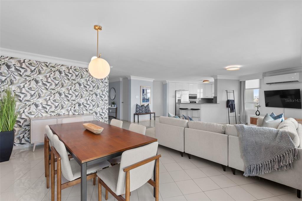 An open-concept living and dining area features a patterned accent wall, tile flooring, and kitchen — 550 AVE DE LA CONSTITUCION UNIT 1010, SAN JUAN, PR