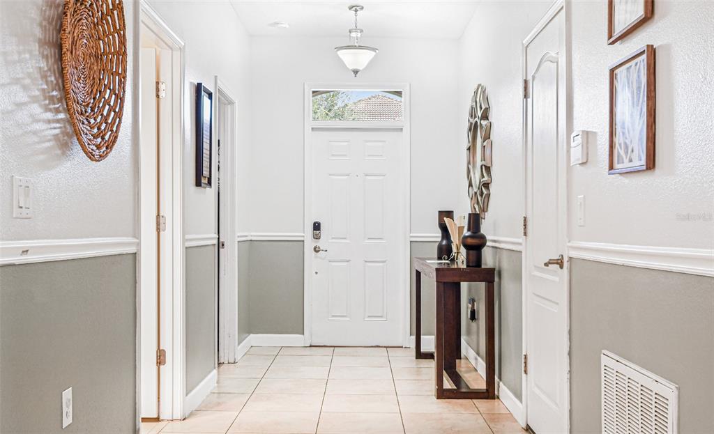 A kitchen with dark wood cabinets and stainless steel appliances opens to a living area — 9026 SHADOW MOUNTAIN STREET, DAVENPORT, FL