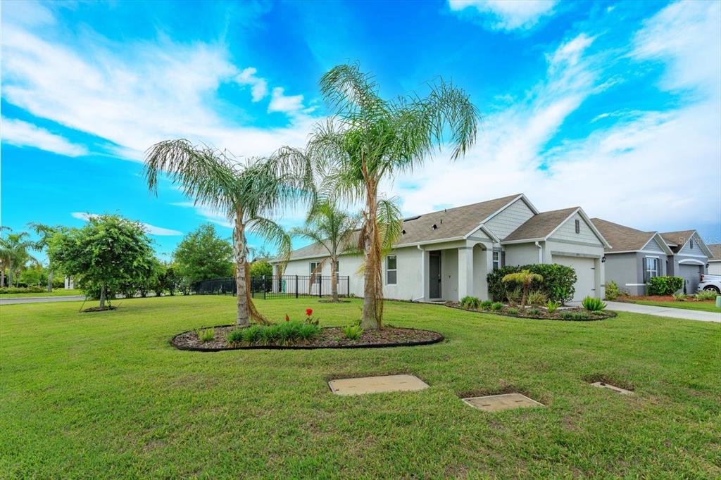 A single-story house with a tan exterior, a two-car garage, and palm trees in the yard — 3075 GIBRALTAR BOULEVARD, NEW SMYRNA BEACH, FL