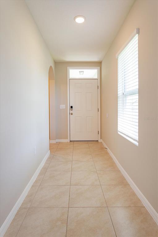A tiled entryway features a white front door with a transom window and beige walls — 3075 GIBRALTAR BOULEVARD, NEW SMYRNA BEACH, FL