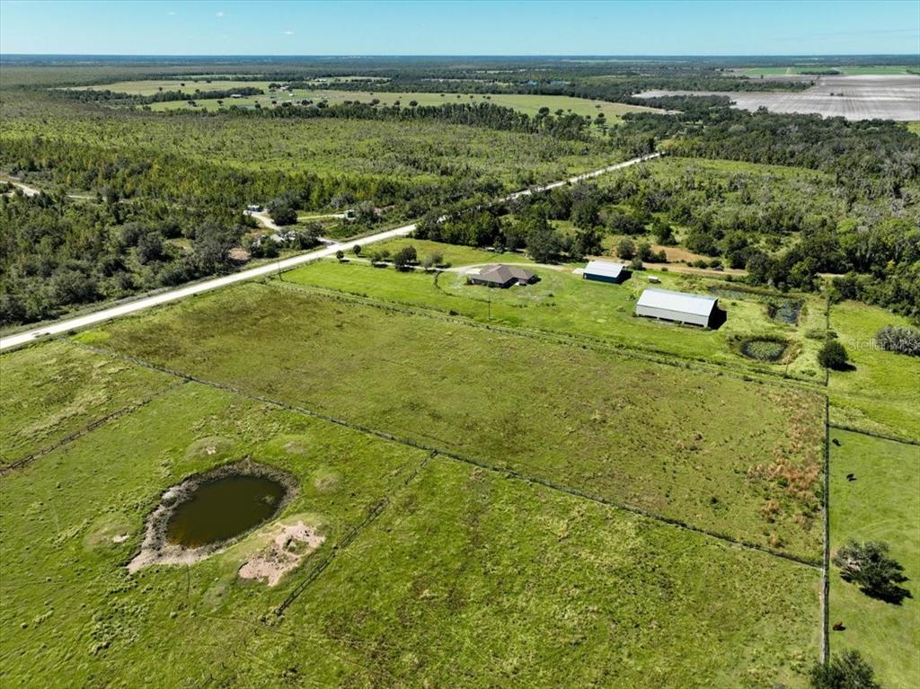An aerial view shows a rural property with a house, outbuildings, and a small pond — 39605 TAYLOR ROAD, MYAKKA CITY, FL