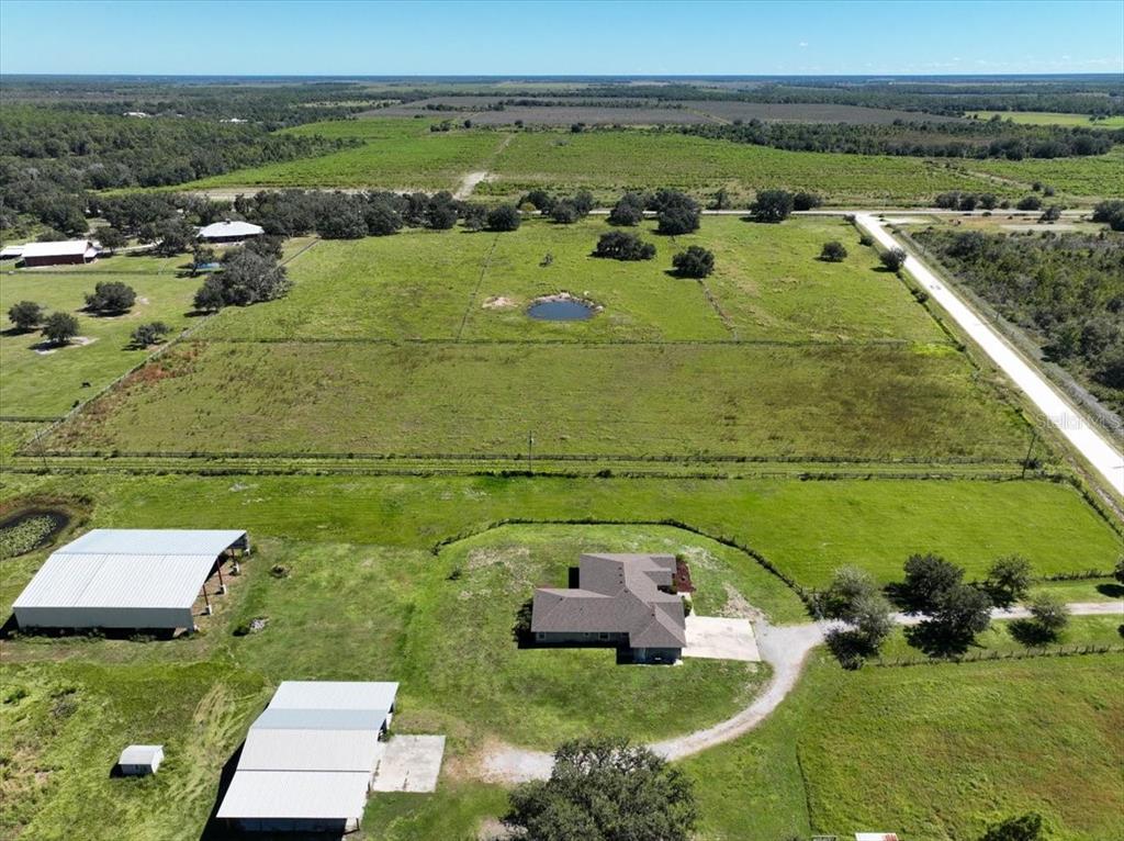 An aerial view shows a house, two outbuildings, and a pond on a large property — 39605 TAYLOR ROAD, MYAKKA CITY, FL