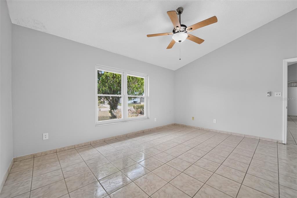 An empty room with light gray walls, tile flooring, a ceiling fan, and a window — 1224 ANDES DR, WINTER SPRINGS, FL