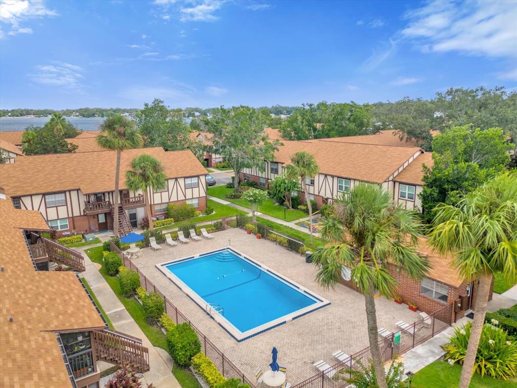 An aerial view shows a swimming pool surrounded by apartment buildings and a parking lot — 5419 HANSEL AVENUE UNIT K12, ORLANDO, FL