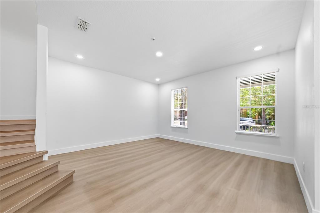 A view from a hallway looking into a bathroom and an adjacent living area — 10359 LAKE DISTRICT LANE UNIT 58B, ORLANDO, FL