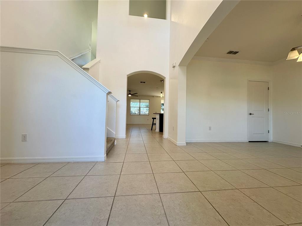 A tiled entryway leads to a staircase and an arched opening into a kitchen area — 177 BELLA VERANO WAY, DAVENPORT, FL