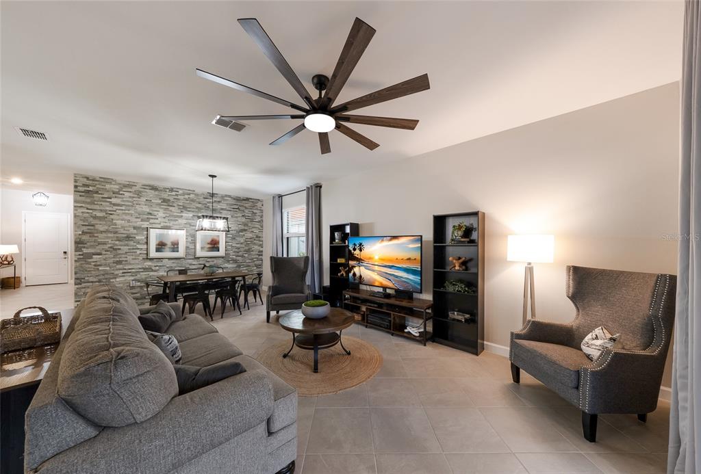 A modern kitchen features white cabinetry, a large island with a sink, and pendant lighting — 15041 SERENE SHORES LOOP, BRADENTON, FL
