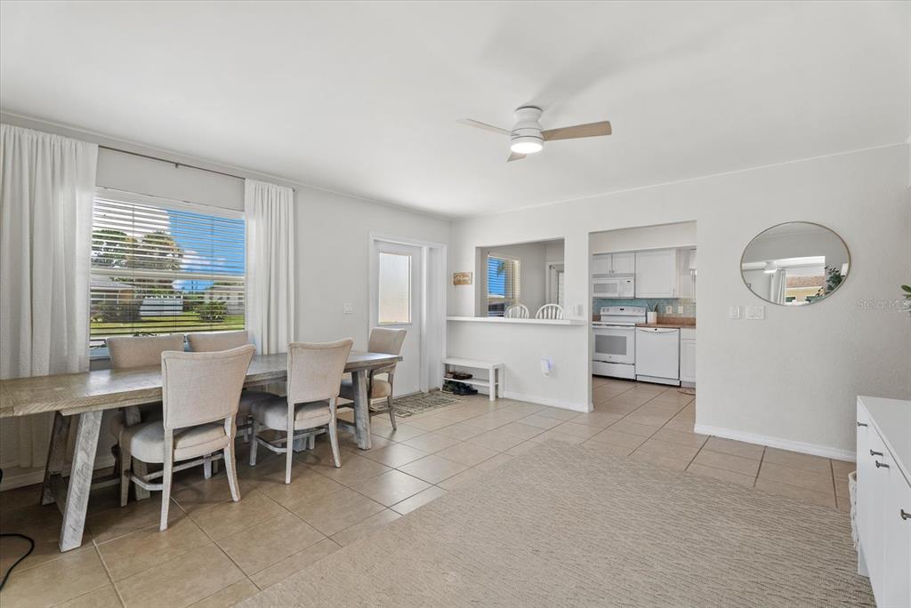A dining area with tile floors, a wooden table, and an opening to the kitchen — 6315 JORDAN STREET, NORTH PORT, FL