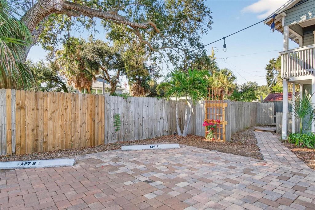 A paved parking area with two designated spots sits in front of a wooden fence — 509 29TH AVENUE S, ST PETERSBURG, FL