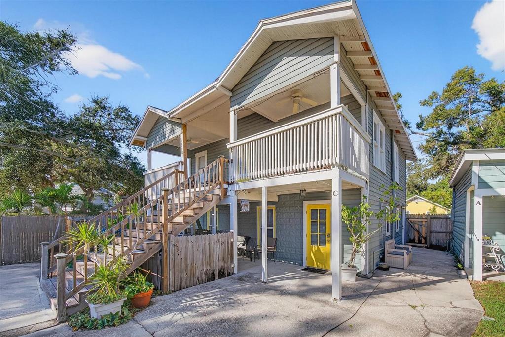 A two-story house with a yellow door, wooden stairs, and a covered balcony — 509 29TH AVENUE S, ST PETERSBURG, FL