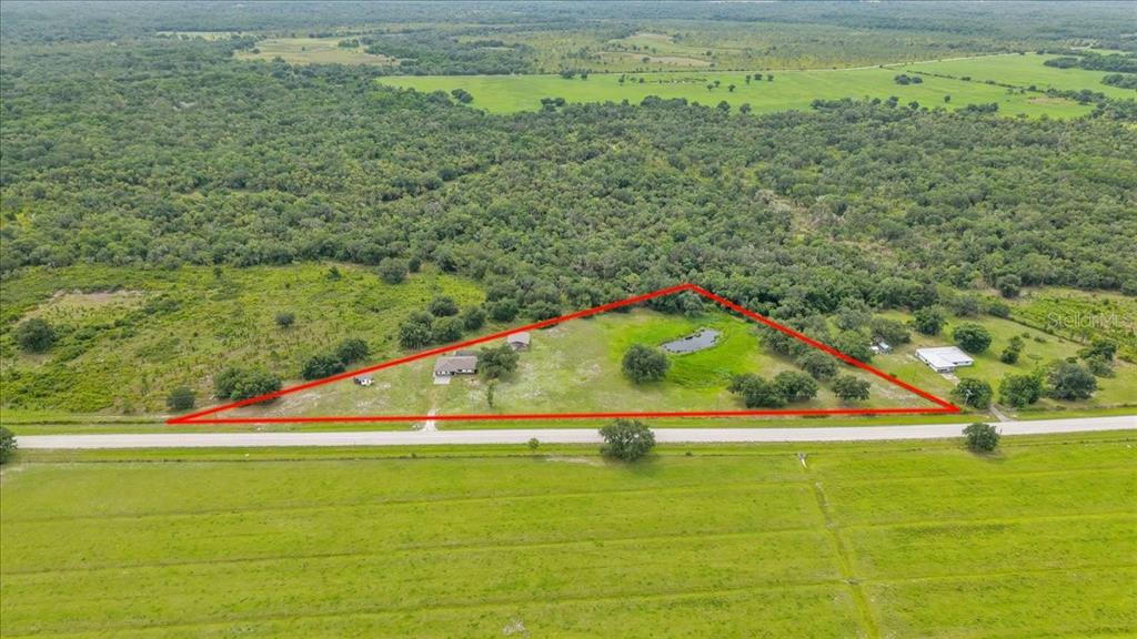 An aerial view shows a triangular property with a house, outbuilding, and pond — 4806 SW COUNTY ROAD 769, ARCADIA, FL