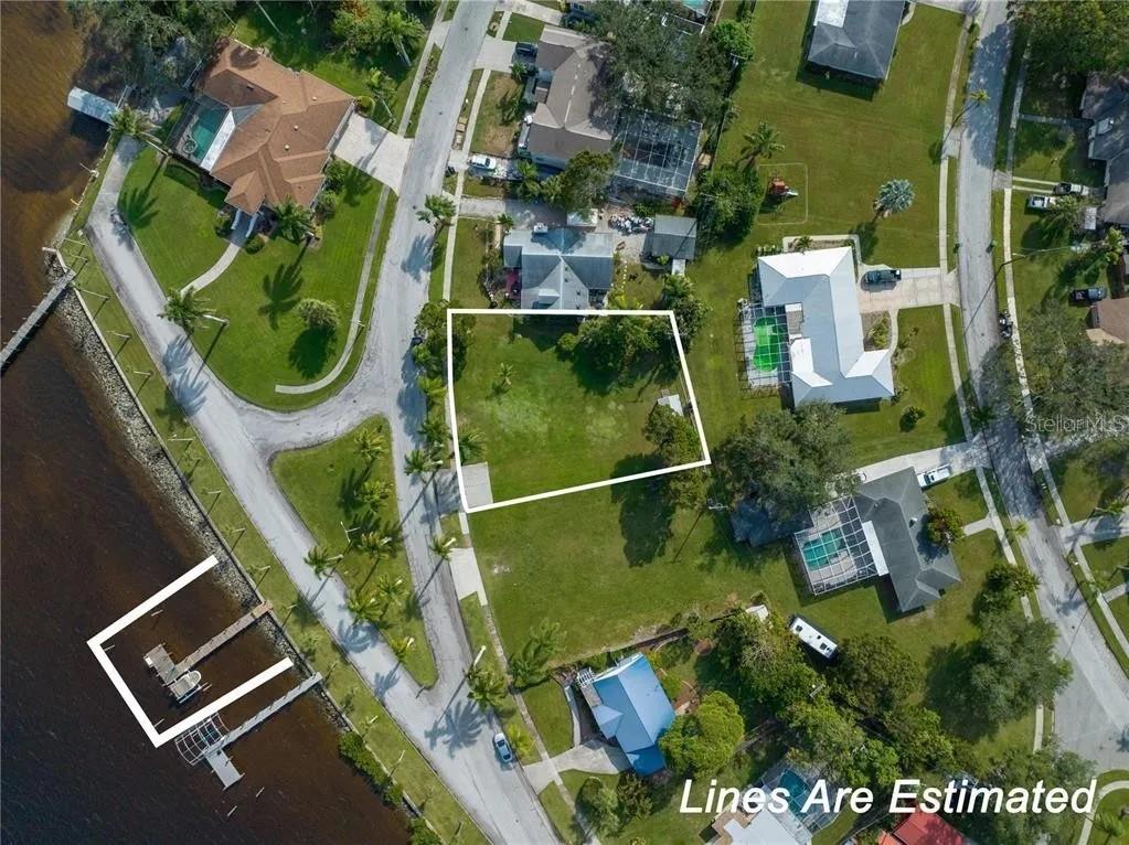 An aerial view shows a vacant residential lot outlined in white near a waterfront — 2520 RIVERSIDE DRIVE E, BRADENTON, FL