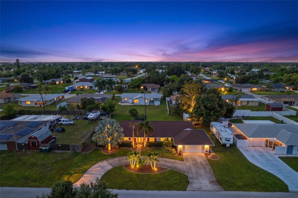 An aerial view of a single-story house with a circular driveway and palm trees — 22112 BRONXVILLE AVENUE, PORT CHARLOTTE, FL