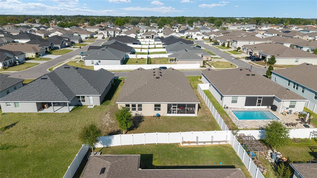 An aerial view shows suburban houses with fenced backyards and a swimming pool — 8285 SW 58TH AVENUE, OCALA, FL