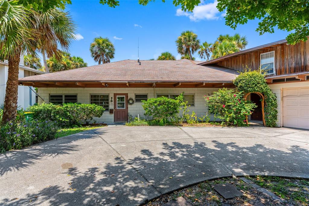 A single-story house with a concrete block exterior, a brown roof, and a paved driveway — 1230 S ORLANDO AVENUE, COCOA BEACH, FL