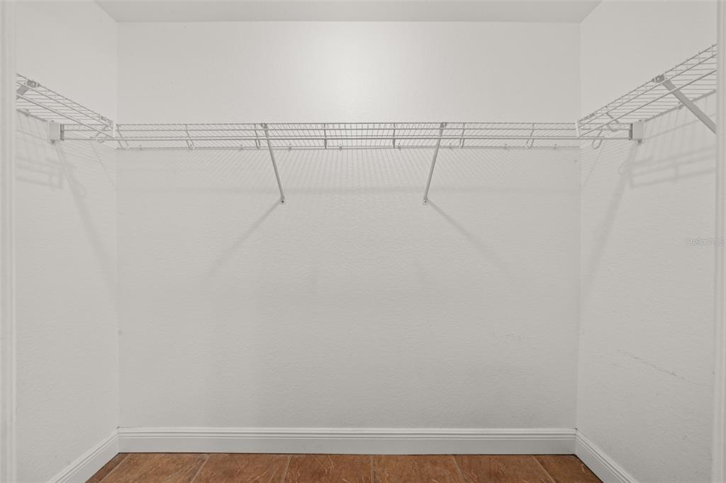 A walk-in closet features white wire shelving mounted on the walls above tiled flooring — 615 GRAHAM DAIRY RD, VENUS, FL