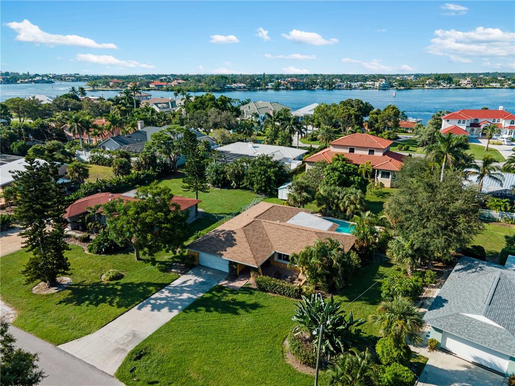 An aerial view shows a residential neighborhood with houses, green lawns, and a nearby waterway — 424 BAYCREST DRIVE, VENICE, FL