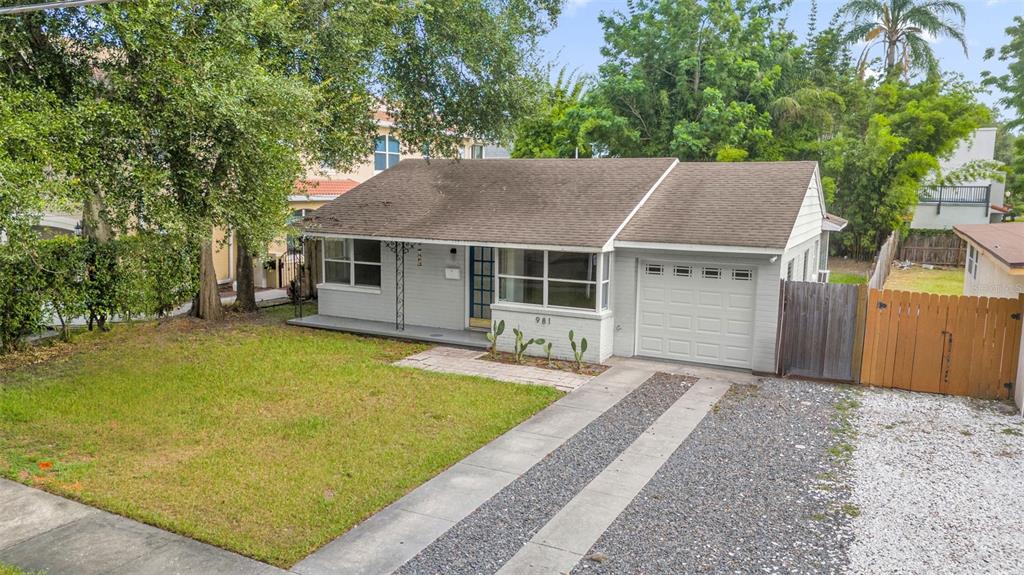 A bathroom features a white vanity, a toilet, a mirror, and gray tiled walls — 981 ARAGON AVENUE, WINTER PARK, FL