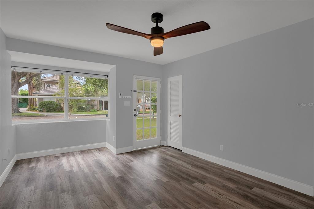 An empty room features light gray walls, wood-look flooring, and a large window — 981 ARAGON AVENUE, WINTER PARK, FL